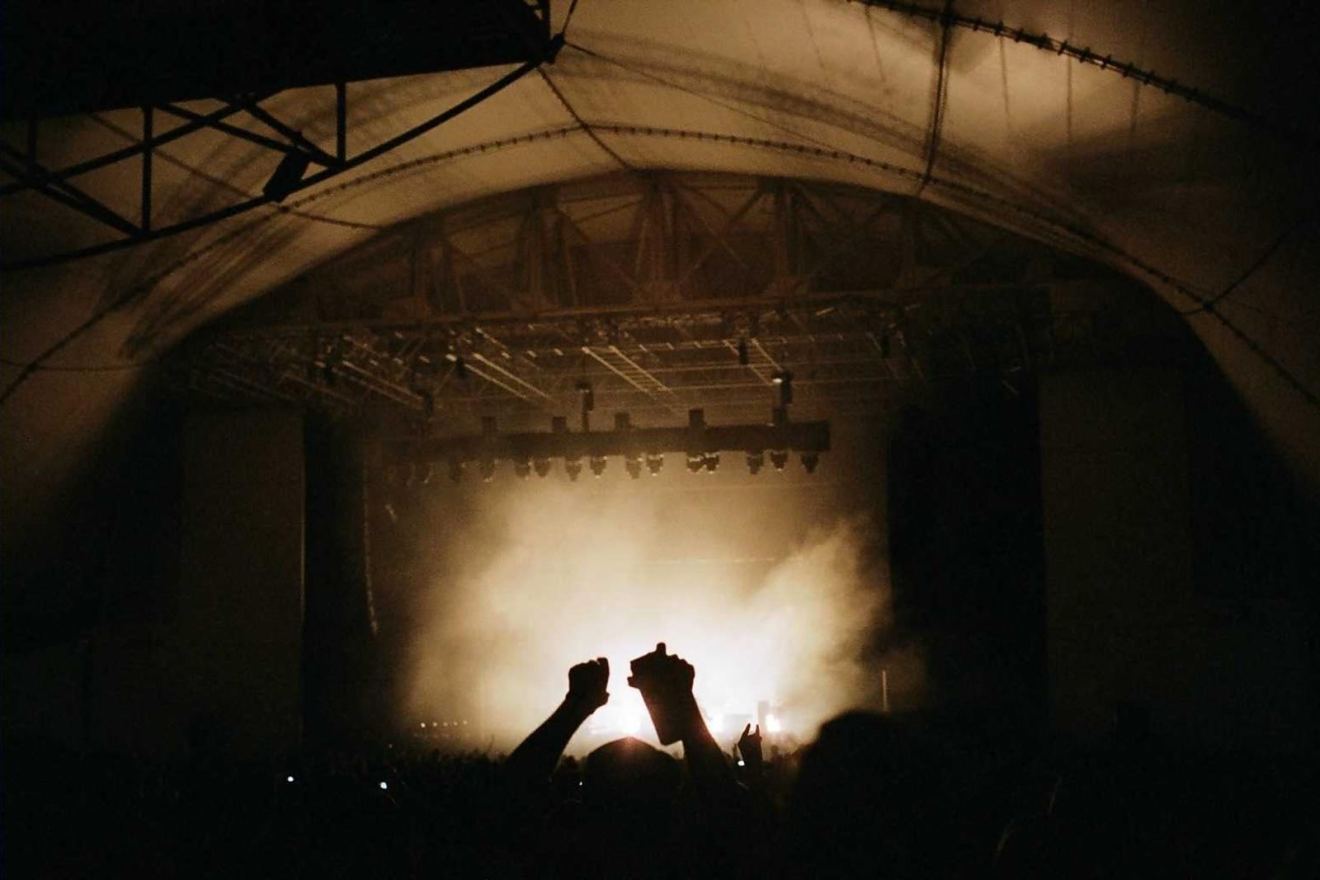 Silhouetted hands raised at a concert