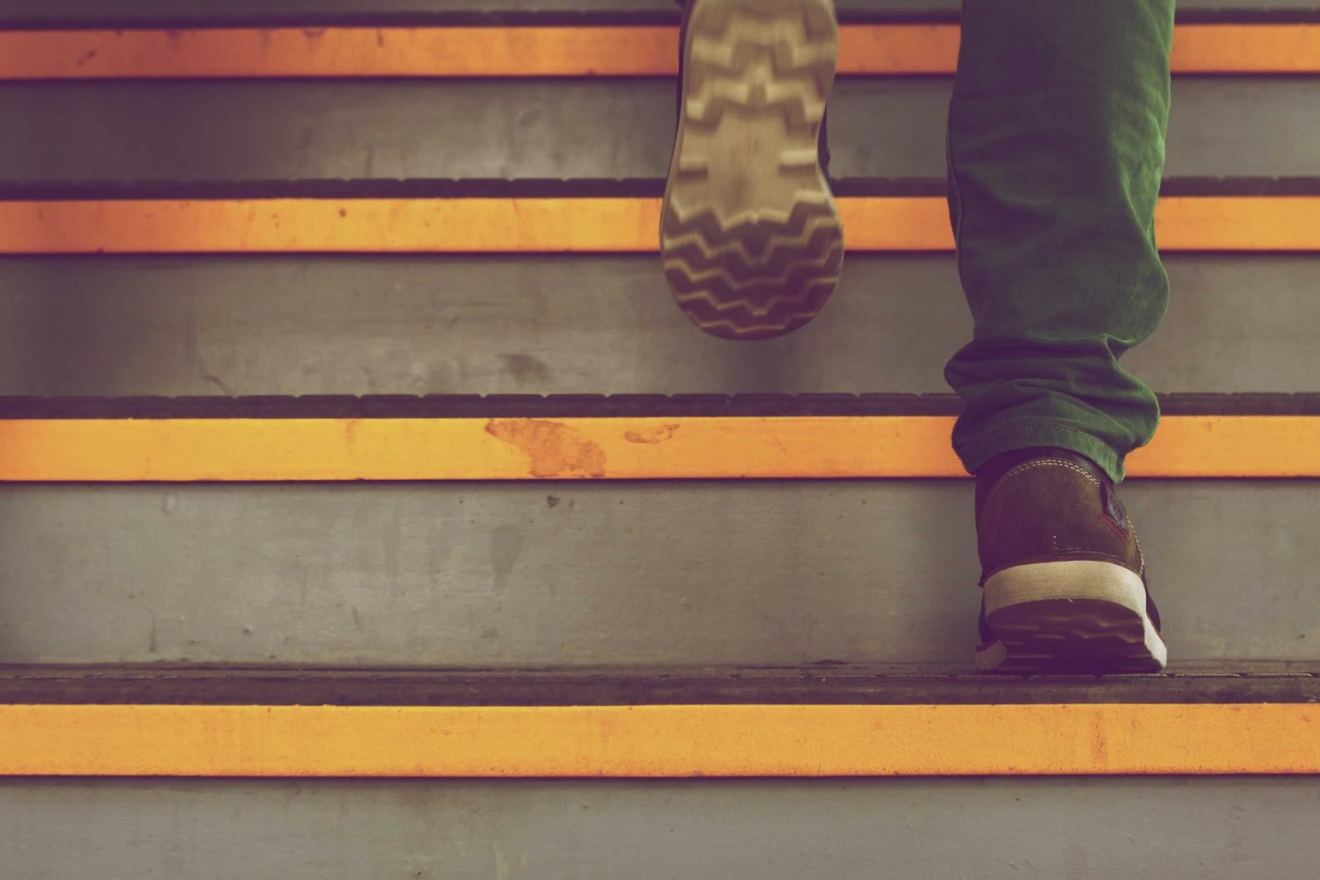 A runner's foot on a yellow stadium step