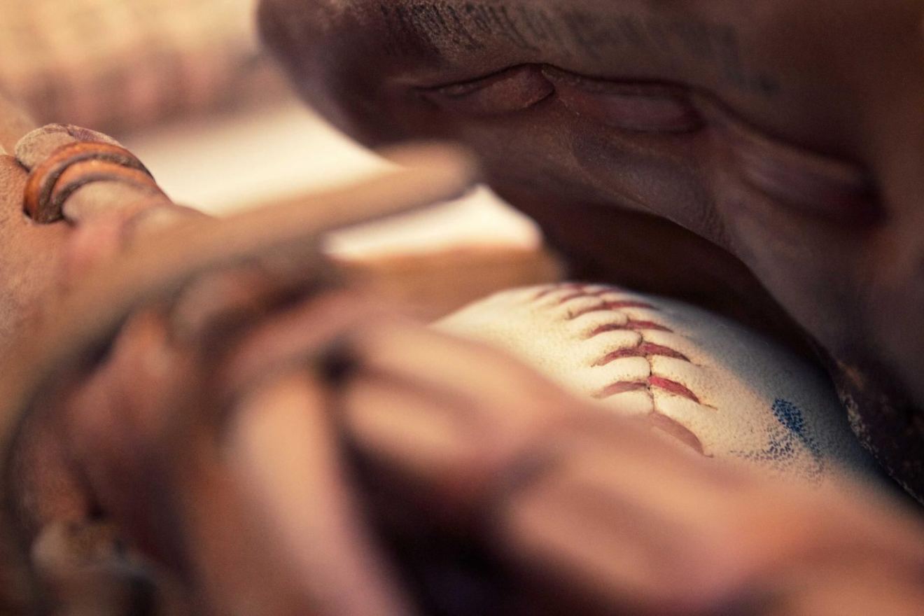 A baseball resting in a leather glove