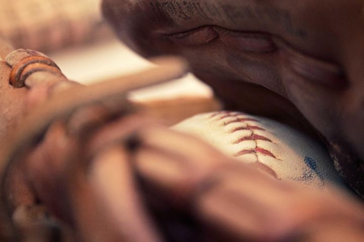 A baseball resting in a leather glove